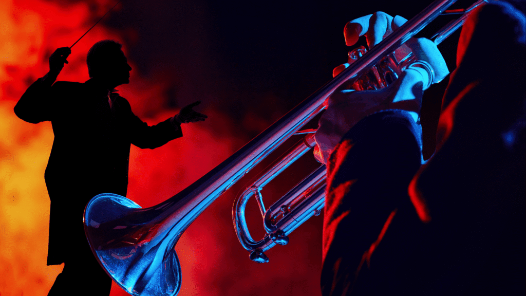 Image of a jazz trumpet over a dark and moody background with the shadow of a conductor visible in the glowing fog in the background intended to symbolize the importance of using an appropriate leadership style that allows for flexibility and experimentation in your SMB.