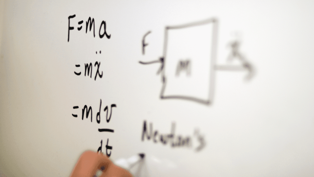 Picture of Newton's second law drawn on a whiteboard with the formula F=ma visible with a blurred representation of force, mass, and acceleration on the right.