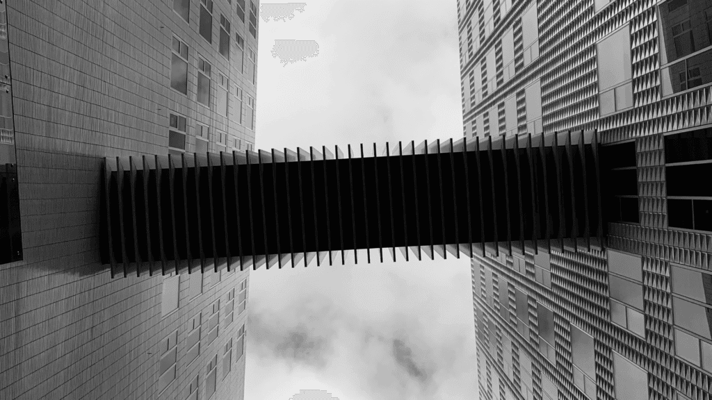Picture looking up at a bridge between two buildings, signifying the importance of bridging ideas and helping people cross between parts of the elephant to see the big picture.