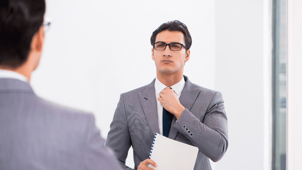 SMB business leader checking himself in the mirror while holding his presentation notes. Signifies the importance of preparation and practice to hit a home run with your next pitch.